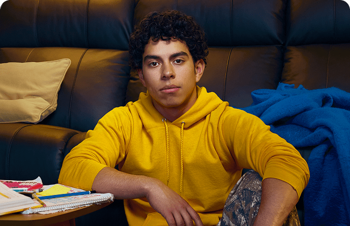 Jayden, a 16-year-old with ADHD, on the floor with a couch behind him.
