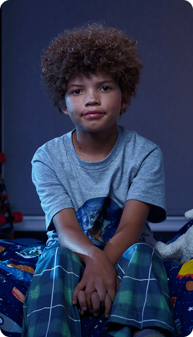 Leo, a 9-year-old boy with ADHD, on his bed.