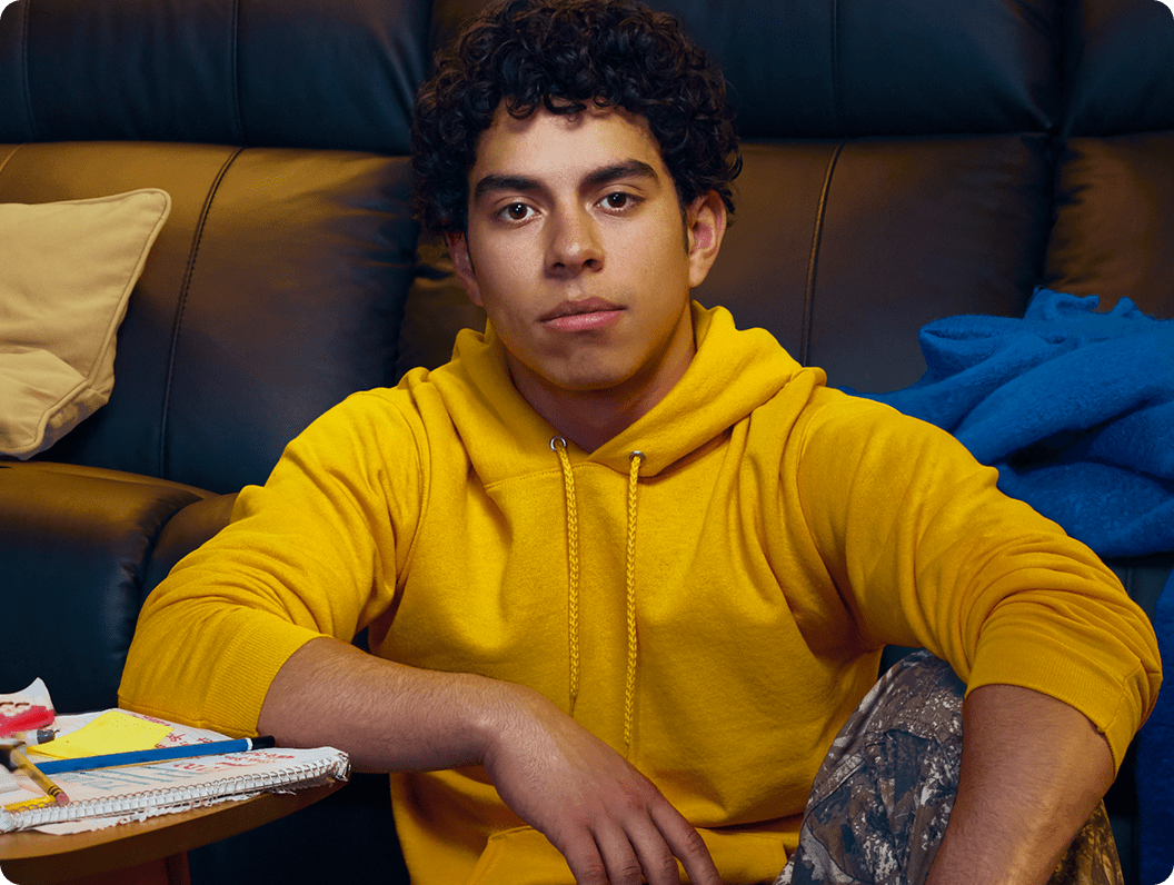 Jayden, a 16-year-old with ADHD, on the floor with a couch behind him.