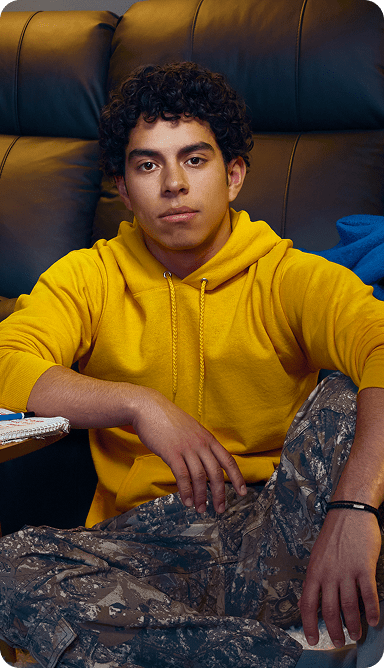Jayden, a 16-year-old with ADHD, on the floor with a couch behind him.