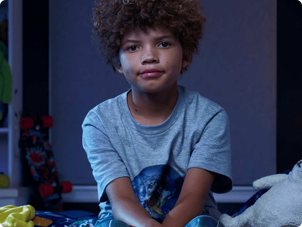 Leo, a 9-year-old boy with ADHD, on his bed.