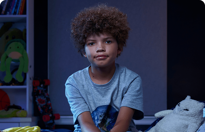 Leo, a 9-year-old boy with ADHD, on his bed.